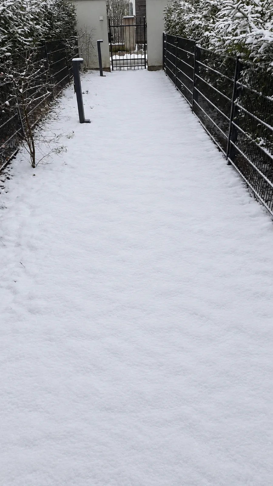 Zugang mit Schnee auf den Pflastersteinen