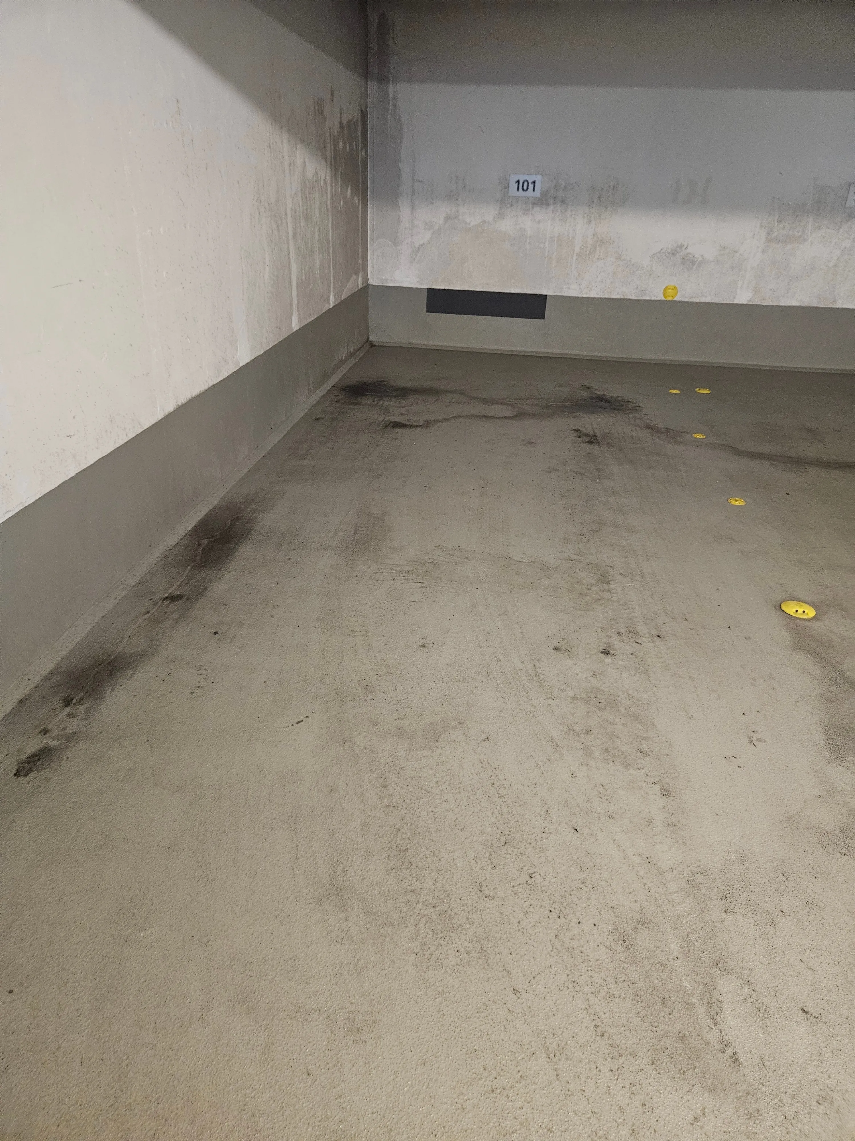 Stellplatzfläche in einer Tiefgarage mit dunklen Spuren auf dem Boden