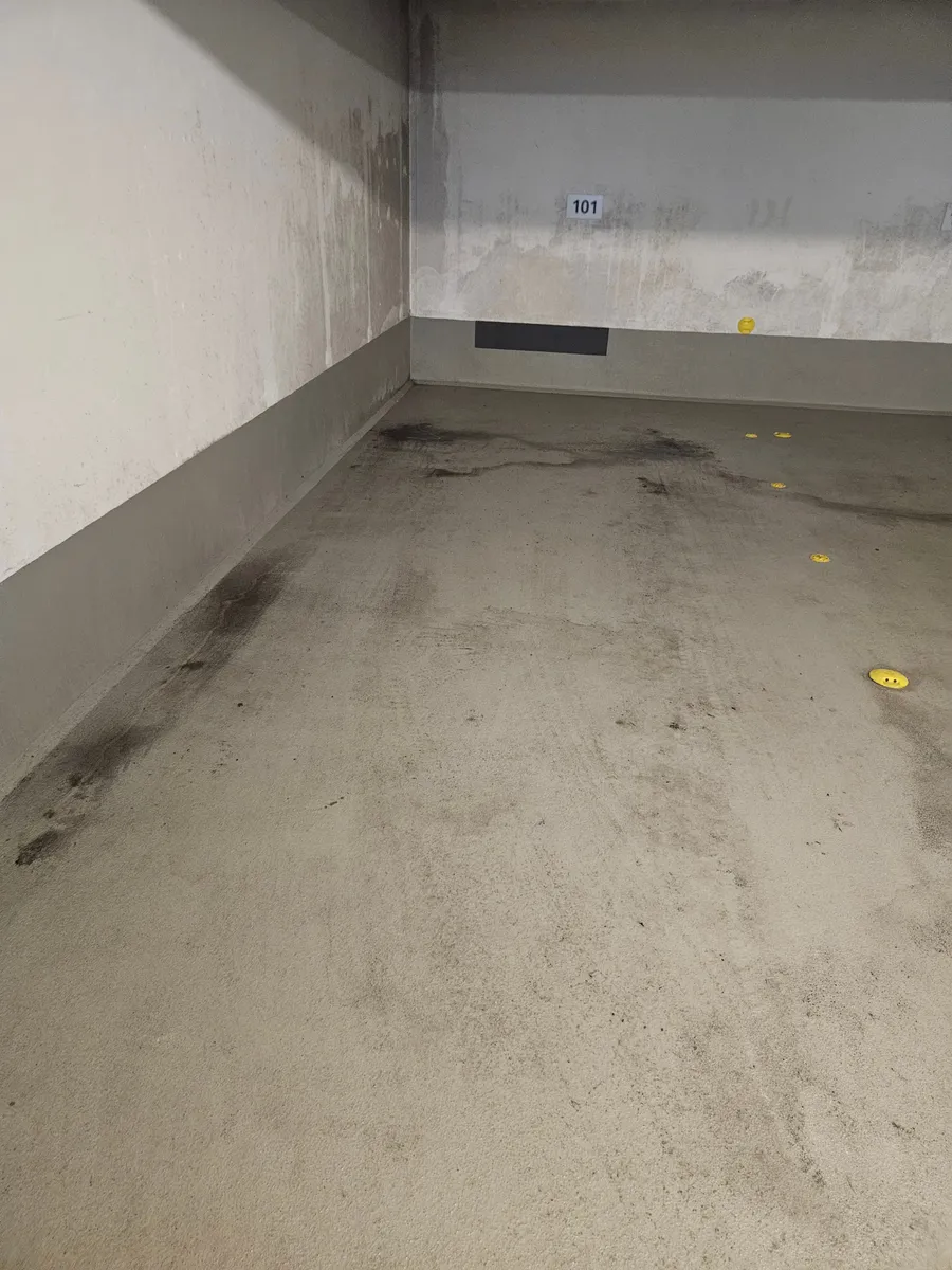 Stellplatzfläche in einer Tiefgarage mit dunklen Spuren auf dem Boden