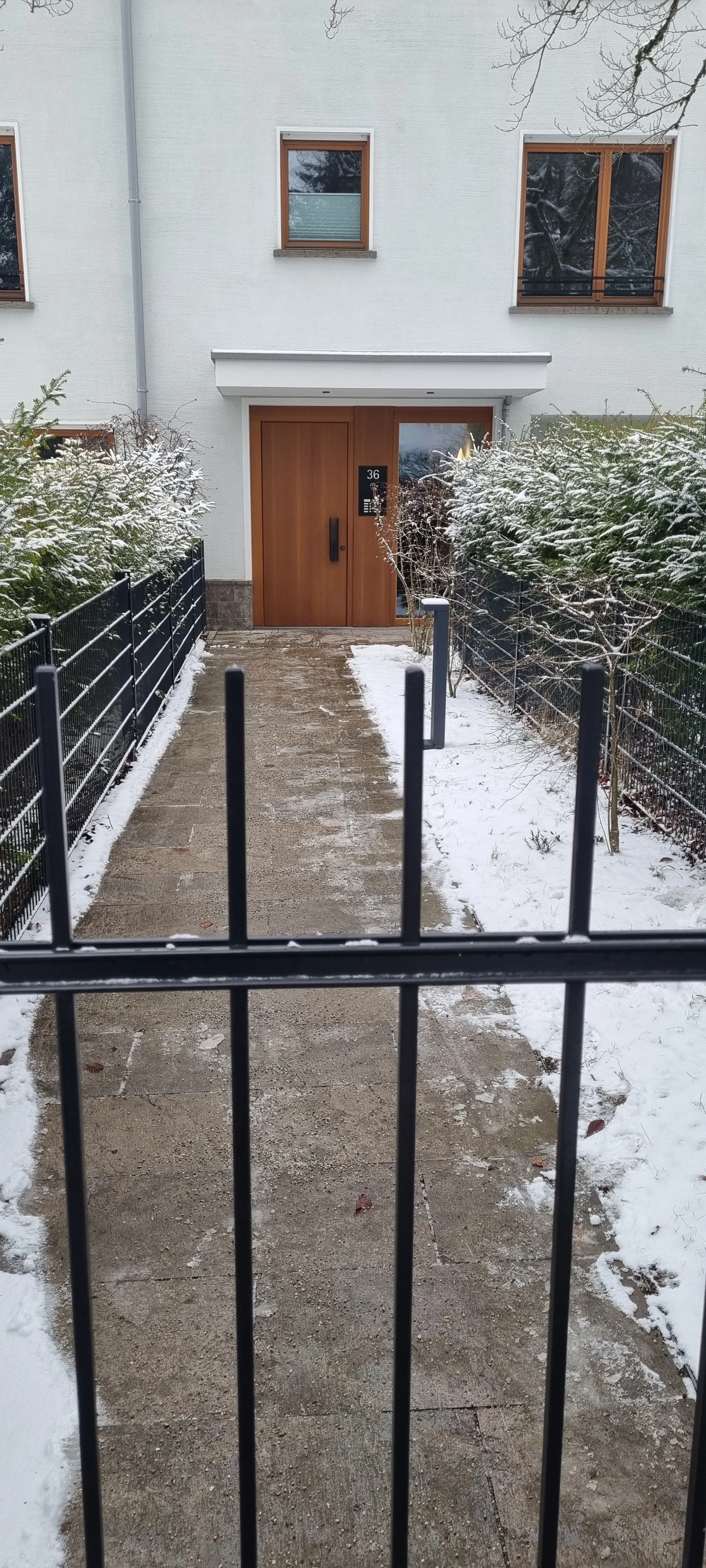 Zugang mit freigeräumtem Pflasterstreifen und Schnee am Rand